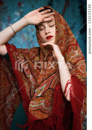 Slavic girl in a scarf on blue background 114133336