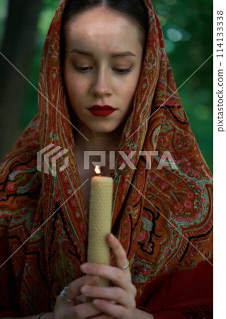 woman with candle prays in the forest woman with candle prays in the forest 114133338