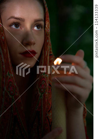 woman with candle prays in the forest woman with candle prays in the forest 114133339