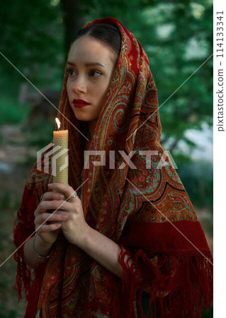 woman with candle prays in the forest woman with candle prays in the forest 114133341