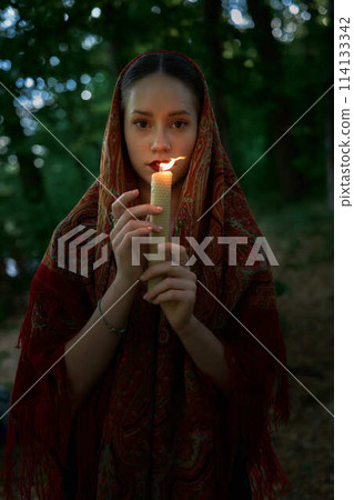 woman with candle prays in the forest woman with candle prays in the forest 114133342