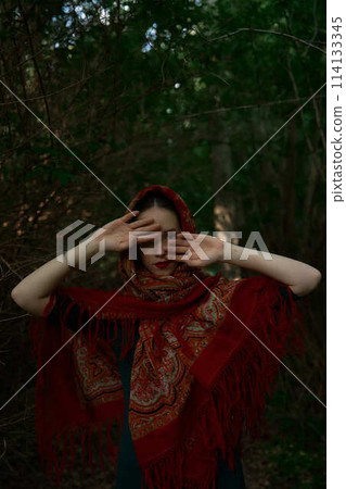 Slavic girl in a scarf pray in forest 114133345
