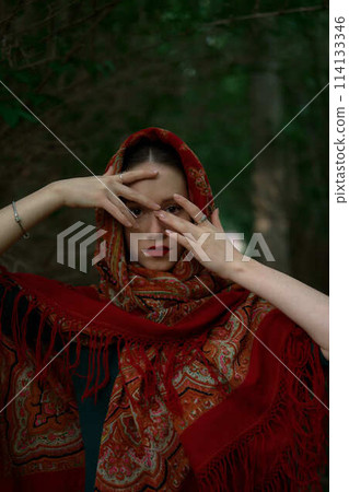 Slavic girl in a scarf pray in forest 114133346