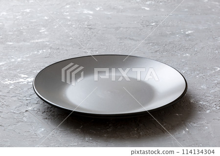 Perspective view of empty grey plate on cement background. Empty space for your design 114134304