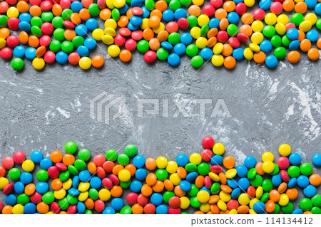 Mixed collection of colorful candy, on colored background. Flat lay, top view. frame of colorful chocolate coated candy 114134412