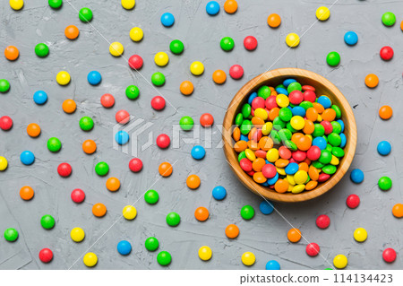 Multicolored candies in a bowl on a colored background. birthday and holiday concept. Top view with copy space Multicolored candies in a bowl on a colored background. birthday and holiday concept. Top view with copy space 114134423