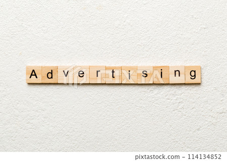 ADVERTISING word written on wood block. ADVERTISING text on cement table for your desing, concept 114134852