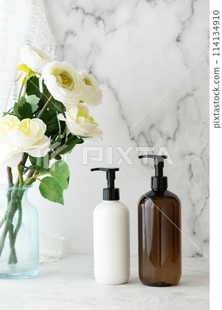 大理石背景上排列的白花和泵型塑膠瓶 大理石背景上排列的白花和泵型塑膠瓶 114134910