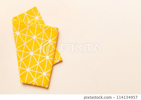 top view with yellow empty kitchen napkin isolated on table background. Folded cloth for mockup with copy space, Flat lay. Minimal style 114134957