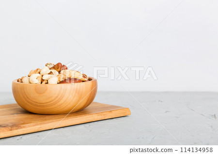 mixed nuts in bowl. Mix of various nuts on colored background. pistachios, cashews, walnuts, hazelnuts, peanuts and brazil nuts 114134958