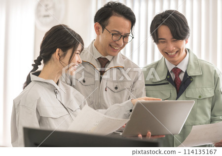 Three male and female engineers in work clothes having a meeting Three male and female engineers in work clothes having a meeting 114135167