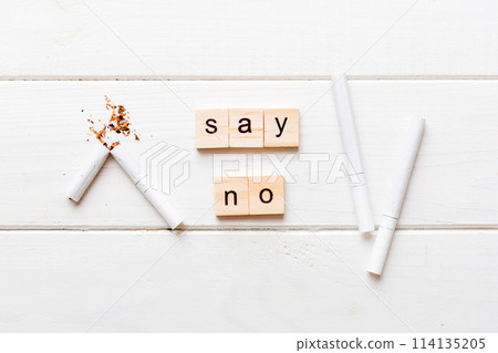 Cigarette And Wooden Blocks, Broken cigarette on table background, No Tobacco Day with hourglass, clock health concept. time to quit smoking Cigarette And Wooden Blocks, Broken cigarette on table background, No Tobacco Day with hourglass, clock health concept. time to quit smoking 114135205