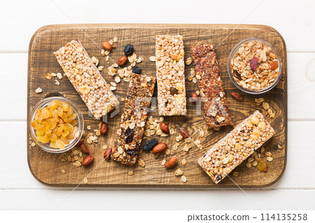 Various granola bars on table background. Cereal granola bars. Superfood breakfast bars with oats, nuts and berries, close up. Superfood concept 114135258