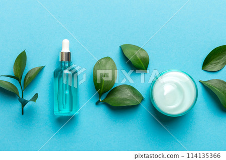 Organic cosmetic products with green leaves on color background Organic cosmetic products with green leaves on color background 114135366