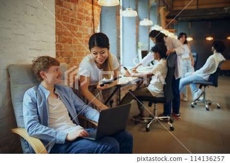 Creative hub. Co-working studio filled with multiethnic people, employees, freelancers cooperating with each other 114136257