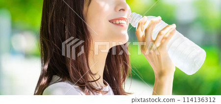 Woman drinking bottled water - summer heat stroke prevention Woman drinking bottled water - summer heat stroke prevention 114136312