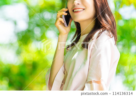 在戶外新鮮綠樹使用智慧型手機的女商人 在戶外新鮮綠樹使用智慧型手機的女商人 114136314