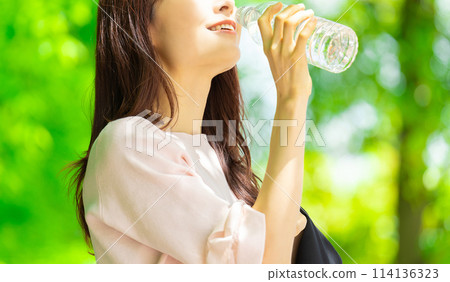 Woman drinking bottled water - summer heat stroke prevention Woman drinking bottled water - summer heat stroke prevention 114136323