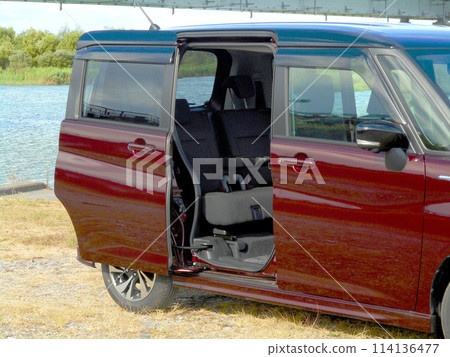 A car with its sliding doors open parked by the river A car with its sliding doors open parked by the river 114136477