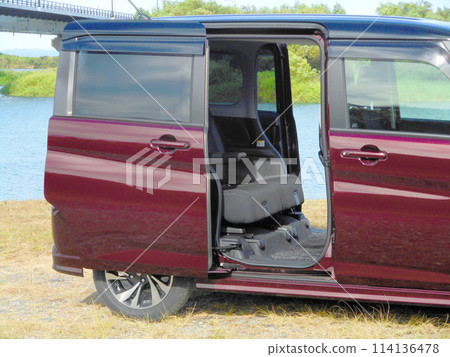 A car with its sliding doors open parked by the river A car with its sliding doors open parked by the river 114136478