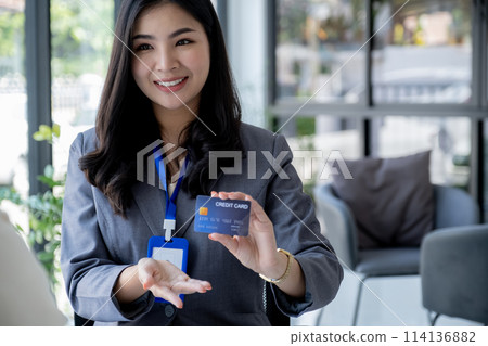 Employees present with mock up credit card payments to business customers. Ready to provide discounts and life insurance Employees present with mock up credit card payments to business customers. Ready to provide discounts and life insurance 114136882