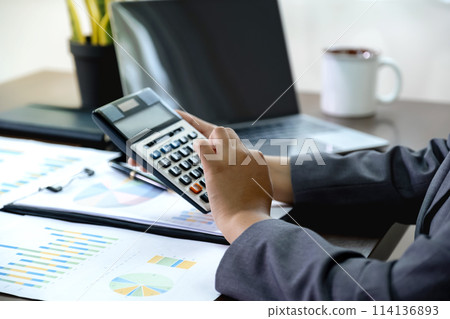 Businesswomen bookkeeper hand use calculator analysis the graph for Setting challenging business goals and ready to achieve target at home office 114136893