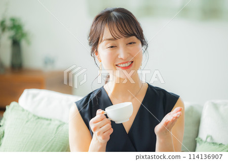 Middle-aged woman drinking coffee in the living room 114136907