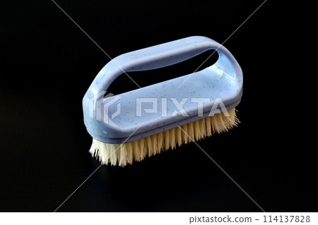 Plastic brush for clothes on a black background. 114137828