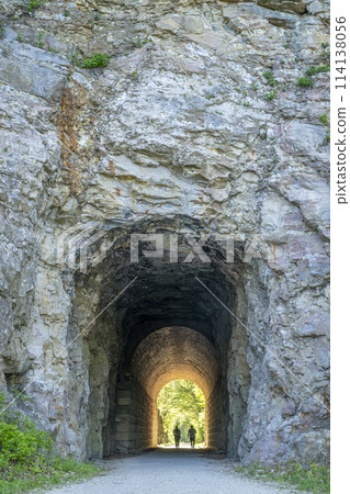 Silhouette of a couple walking through a tunnel on Katy Trail near Rocheport, Missouri. The Katy Trail is 237 mile bike trail converted from an old railroad. 114138056