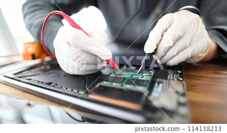 Technician soldering laptop parts 114138213