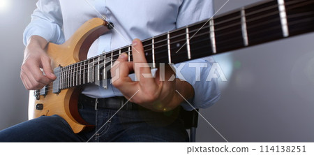 Male arms playing classic shape electric guitar Male arms playing classic shape electric guitar 114138251