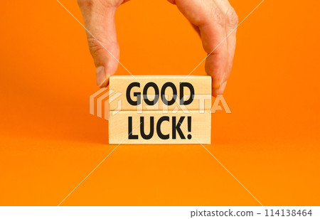 Good luck symbol. Concept words Good luck on beautiful wooden block. Beautiful orange table orange background. Businessman hand. Business, motivational good luck concept. Copy space. 114138464