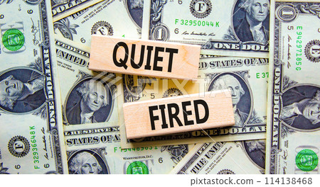 Quiet fired symbol. Concept words Quiet fired on wooden blocks. Beautiful background from dollar bills. Business and quiet fired concept. Copy space. 114138468