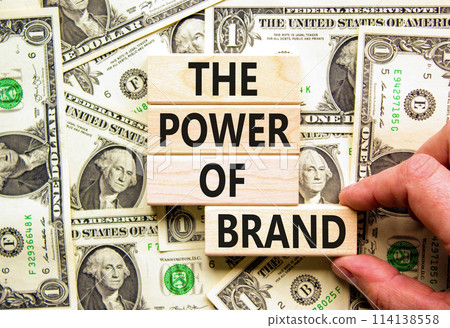 The power of brand symbol. Concept words The power of brand on beautiful wooden block. Beautiful dollar bills background. Businessman hand. Dollar bills. Business power of brand concept. Copy space. 114138558