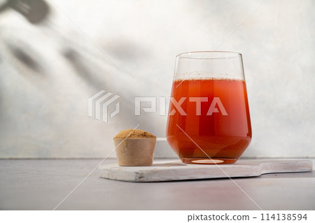 Protein collagen pink powder, fruits and vegetables powder, food supplement in a glass with water 114138594