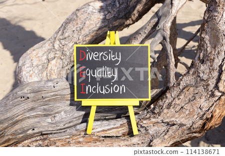 DEI diversity equality inclusion symbol. Concept words DEI diversity equality inclusion on yellow blackboard. Beautiful tree background. Business DEI diversity equality inclusion concept. Copy space. DEI diversity equality inclusion symbol. Concept words DEI diversity equality inclusion on yellow blackboard. Beautiful tree background. Business DEI diversity equality inclusion concept. Copy space. 114138671