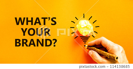 Branding what is your brand symbol. Concept words What is your brand on beautiful orange paper. Beautiful orange background. Businessman hand. Business branding what is your brand concept. Copy space. 114138685