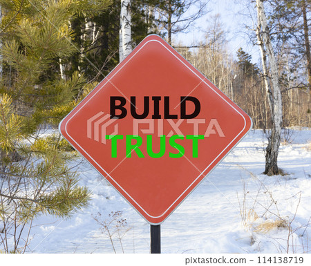 Build trust symbol. Concept words Build trust on beautiful red road sign. Beautiful forest snow blue sky background. Business and build trust concept, copy space. 114138719