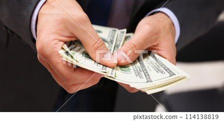 Man in suit and tie hold in arm pack of 114138819