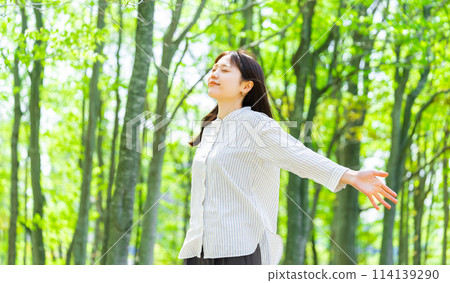 年輕女子在綠樹中深呼吸 114139290