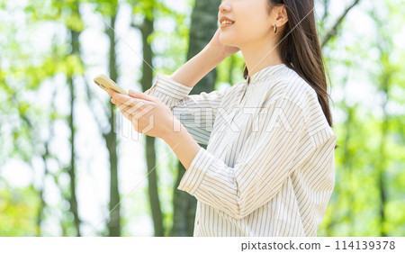 操作智慧型手機的微笑的女商人 操作智慧型手機的微笑的女商人 114139378