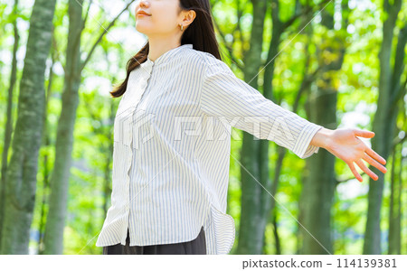Young woman taking a deep breath in the greenery Young woman taking a deep breath in the greenery 114139381