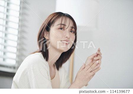 一名20多歲的女性坐在床上 114139677