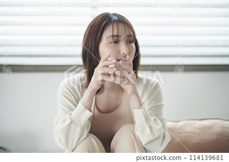 A woman in her twenties drinking water in bed A woman in her twenties drinking water in bed 114139681