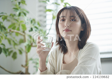 A woman in her twenties drinking water in bed A woman in her twenties drinking water in bed 114139682