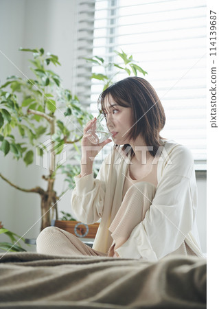20多歲女子躺在床上喝水 20多歲女子躺在床上喝水 114139687