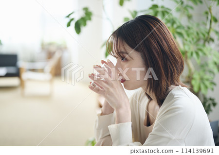 A woman in her twenties drinking water in bed 114139691