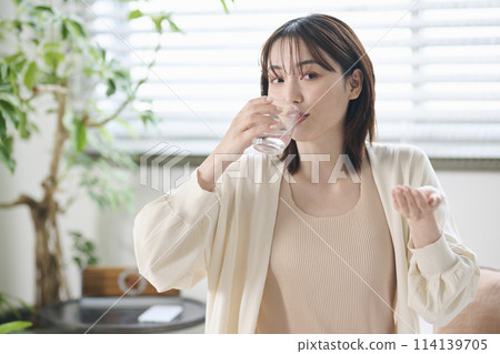 20多歲的女性在床上服用補充劑 114139705