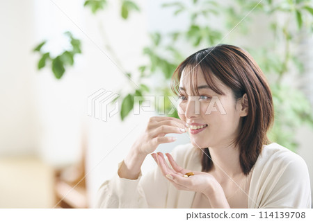 20多歲的女性在床上服用補充劑 20多歲的女性在床上服用補充劑 114139708