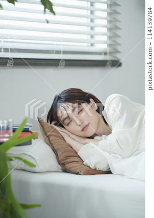 Women in their twenties sleeping in bed Women in their twenties sleeping in bed 114139784